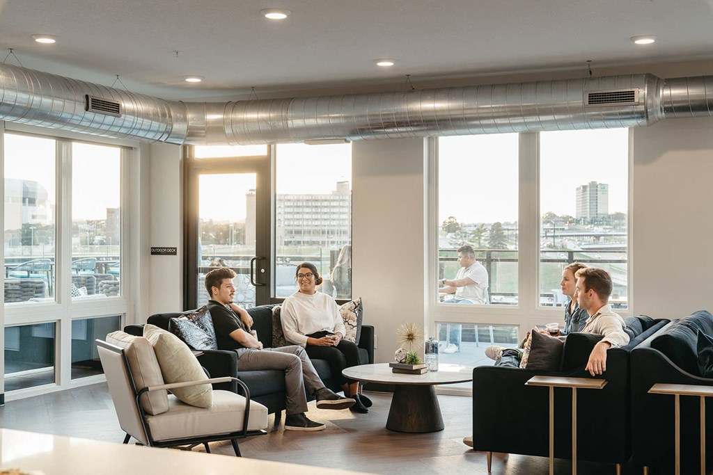 Three men are sitting in a room with a view of the city.at Level, Des Moines, IA  