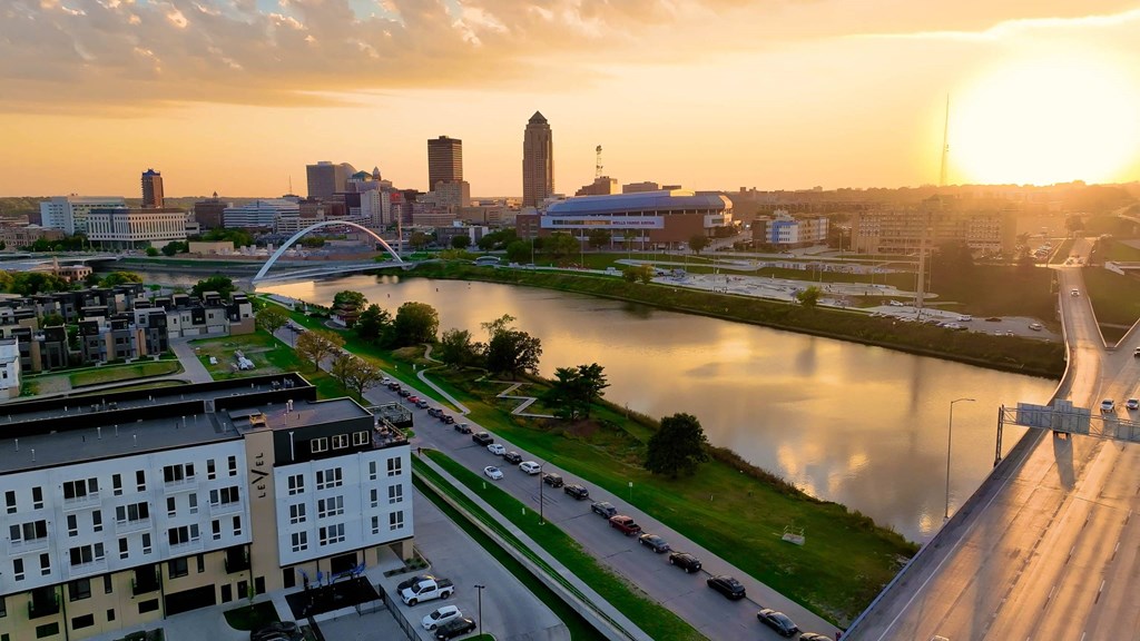 A cityscape with a river and a bridge during sunset.at Level, Des Moines, IA  
