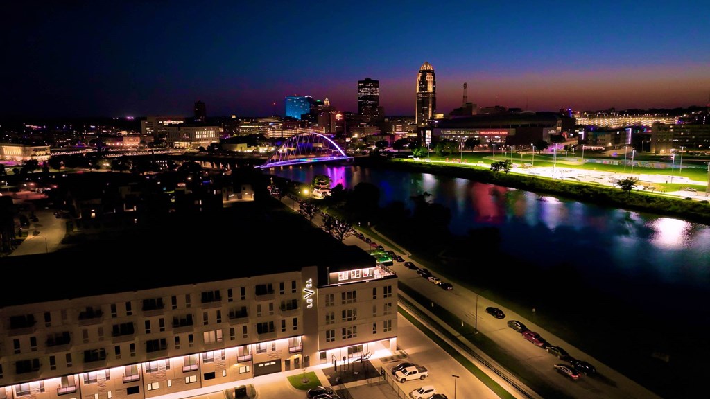 A cityscape at night with a river running through it.at Level, Des Moines, 50309  