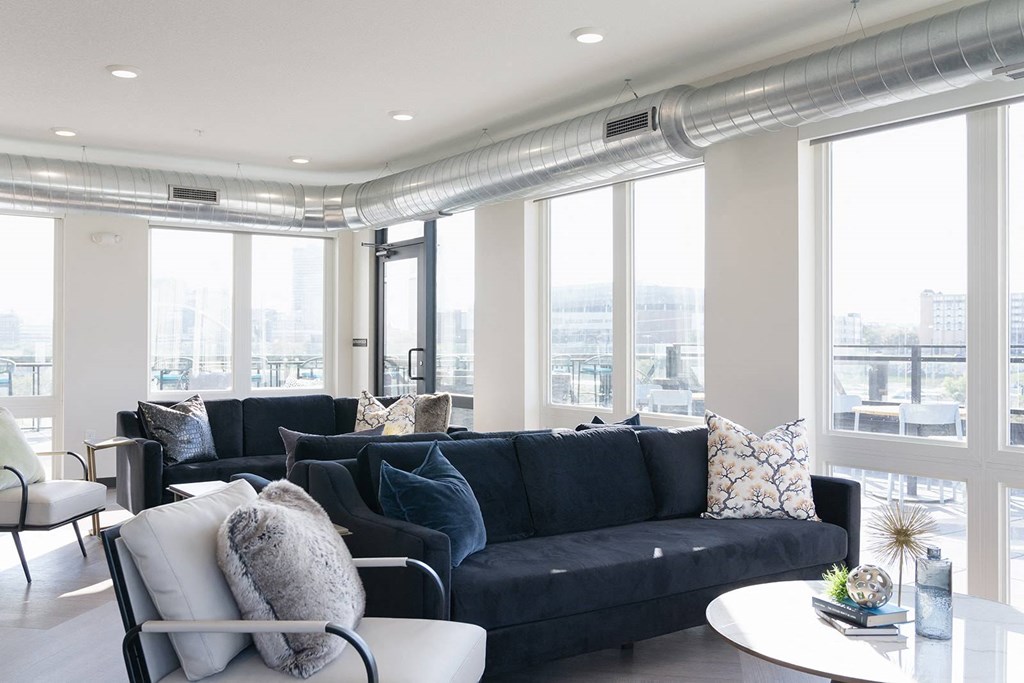 A living room with a black couch and a white chair.at Level, Des Moines, IA 50309  