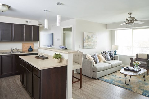 A modern kitchen with dark brown cabinets and a white island.