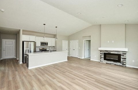 A spacious living room with a fireplace and hardwood floors.