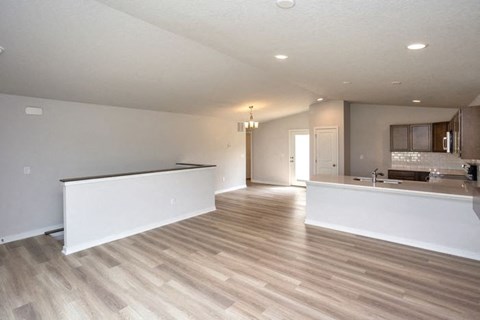 an empty kitchen and living room with a counter top at Two Rivers Home Rentals, West Des Moines, IA 50266
