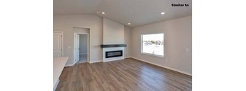 A spacious room with a fireplace and wood flooring. at Two Rivers Home Rentals, Iowa