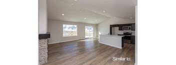 an empty living room with a kitchen and a fireplace at Two Rivers Home Rentals, West Des Moines, IA