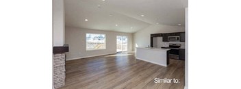 an empty living room with a kitchen and a fireplace at Two Rivers Home Rentals, West Des Moines, IA 50266