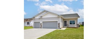 a white house with a driveway and a garage door at Two Rivers Home Rentals, West Des Moines, 50266