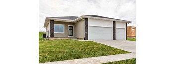 a house with a driveway and a white garage door at Two Rivers Home Rentals, West Des Moines, Iowa
