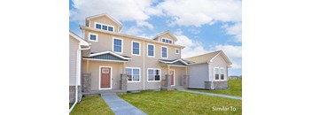 a beige house with a sidewalk in front of it at Two Rivers Home Rentals, West Des Moines, 50266
