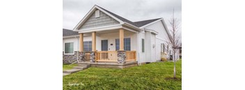 a white house with a porch and a green lawn at Two Rivers Home Rentals, West Des Moines, 50266