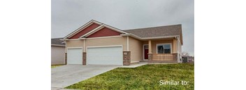 a beige house with a front porch and a garage at Two Rivers Home Rentals, Iowa 50266
