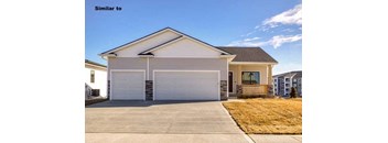 a white house with a white garage door at Two Rivers Home Rentals, Iowa 50266