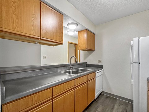A kitchen with wooden cabinets and a white refrigerator.