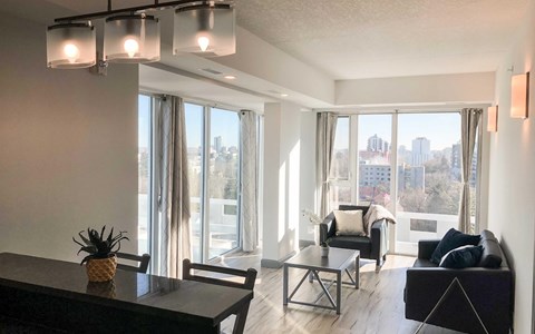 A living room with a view of the city through large windows.
