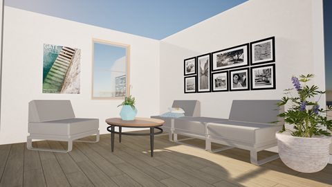 A living room with a grey sofa, a white chair, a round table with a blue vase on it, and a wall with framed pictures.