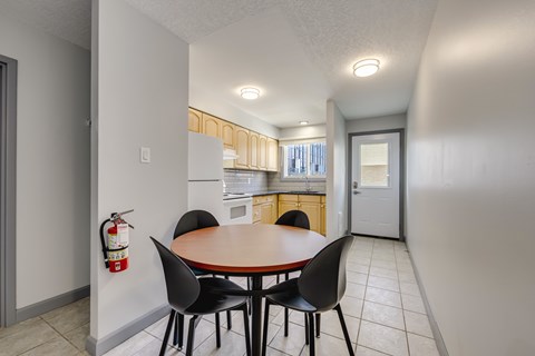 A dining room with a table and chairs.
