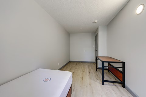 A bedroom with a bed and a table.