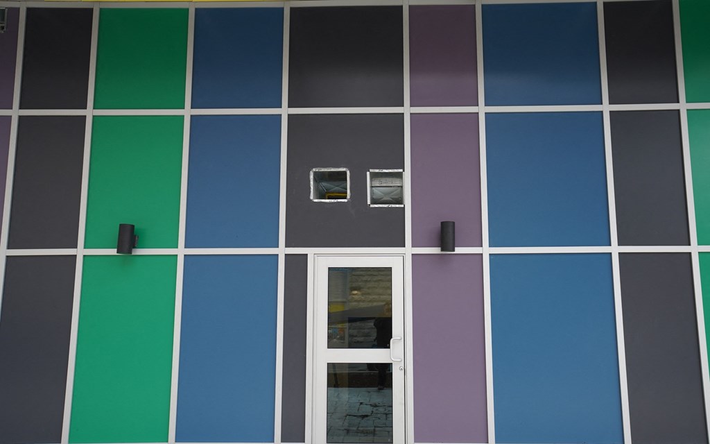 a building with blue and green squares and a white door