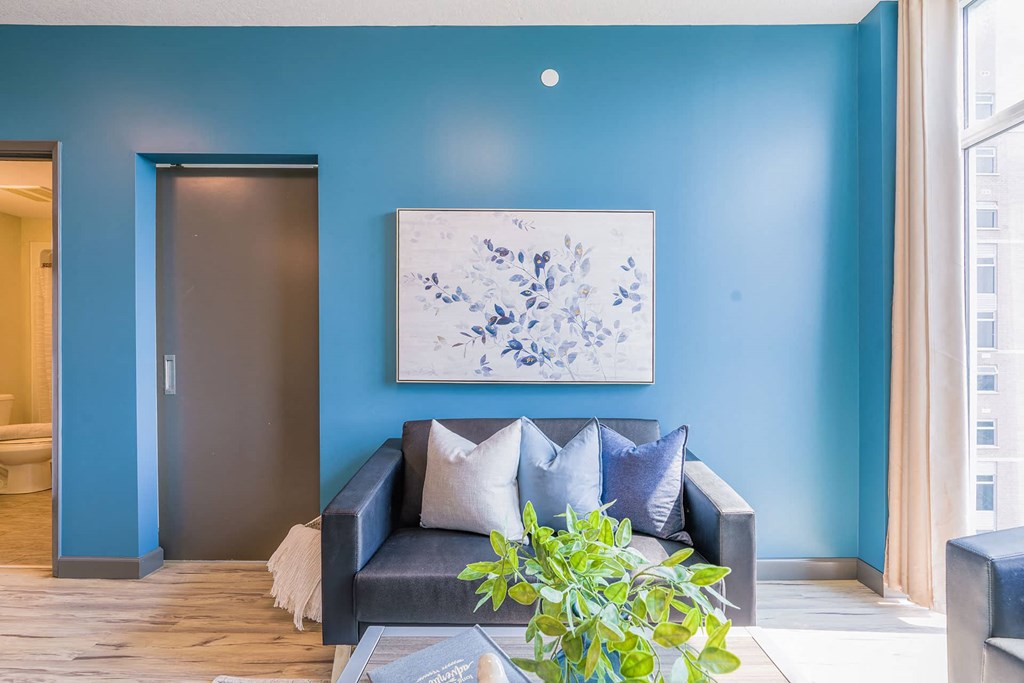 a living room with blue walls and a couch with pillows