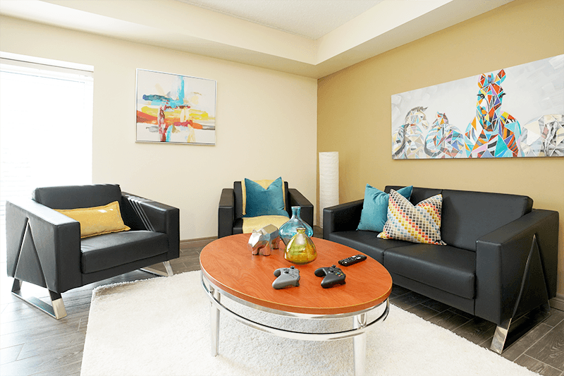 a living room with black couches and a coffee table
