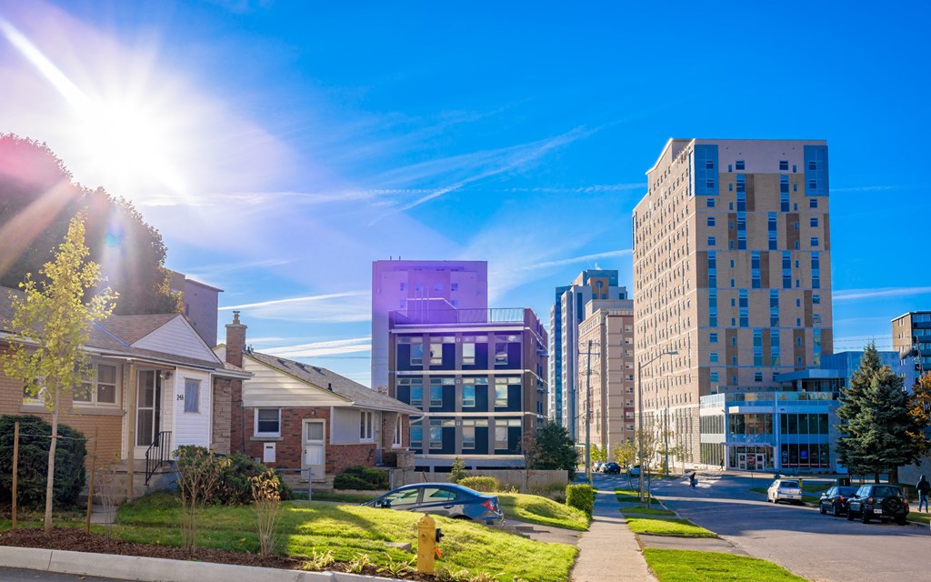 a city street with houses and skyscrapers in the background