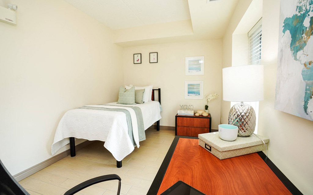 a bedroom with a bed and a table with a lamp