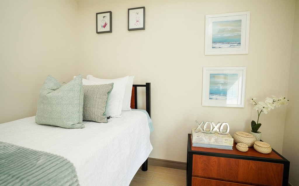 a bedroom with a bed and pictures on the wall