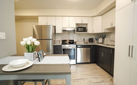 A kitchen with a table and a vase of white flowers.