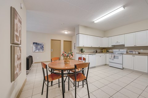 A kitchen with a table and chairs in the middle of the room.
