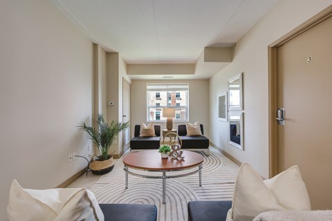 A living room with a striped carpet and a round coffee table.