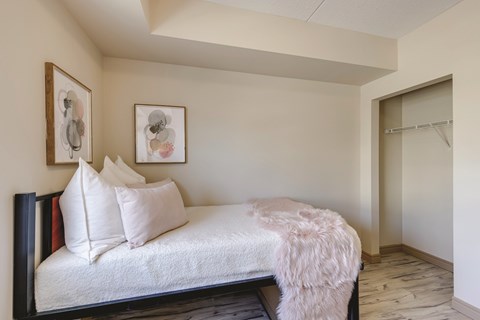 A bedroom with a bed and two framed pictures on the wall.