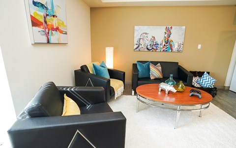 A living room with a black couch and a coffee table.