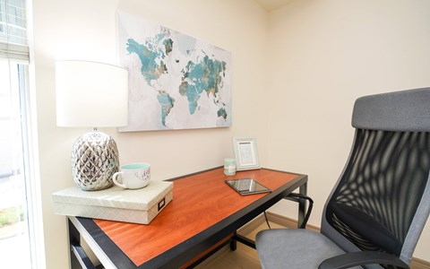 A table with a laptop and a cup on it.