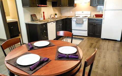 A kitchen with a table set for two.