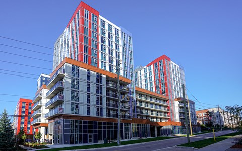 a group of tall buildings with orange balconies on a city street
