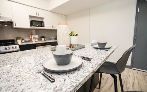 a kitchen with a marble counter top with plates and bowls on it