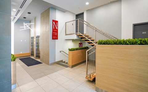 the lobby of a building with a staircase and a reception desk