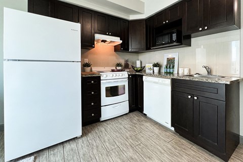a kitchen with white appliances and black cabinets