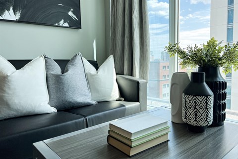 a living room with a couch and a table with books and a vase