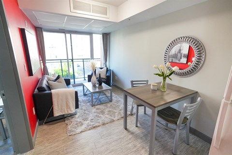 a living room with a dining room table and a large window
