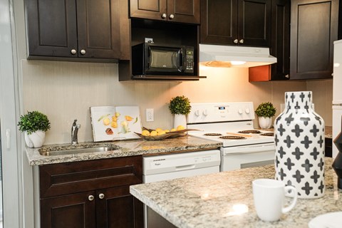 a kitchen with white appliances and granite counter tops