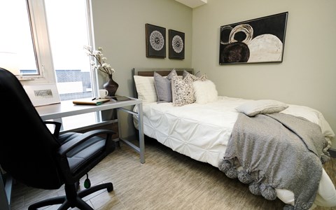 a bedroom with a bed and a desk with a chair