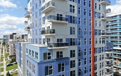 a blue and white building with balconies in a city