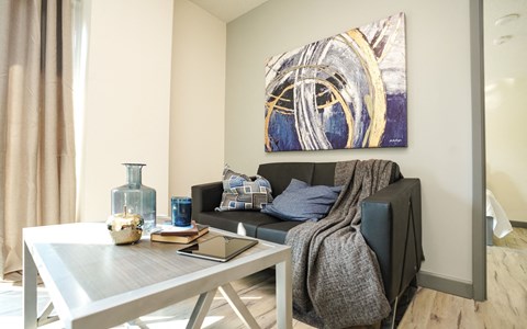 a living room with a couch and a table and a painting on the wall