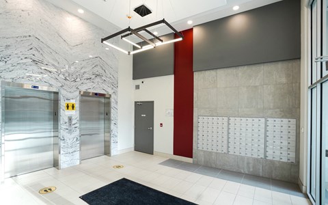 a lobby with elevators and doors and a tile floor