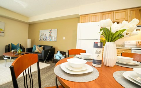 A dining room with a wooden table set for two.