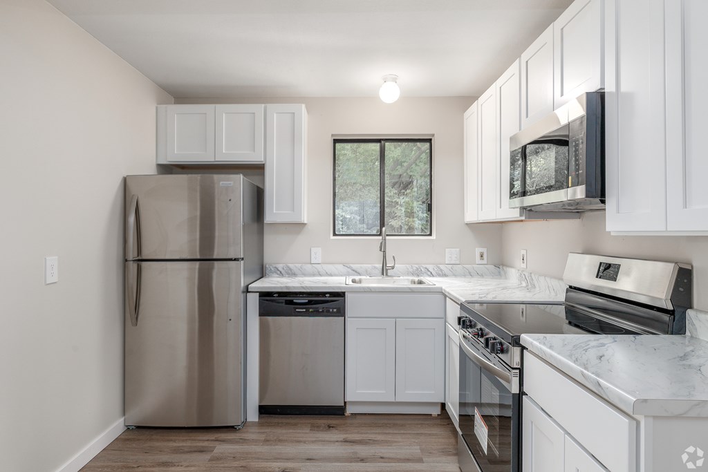 A kitchen with white cabinets and stainless steel appliances.