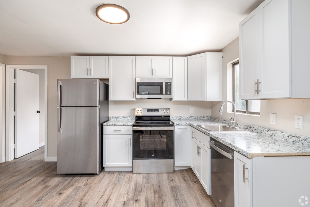 A kitchen with white cabinets and stainless steel appliances.