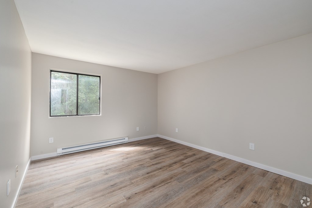 A room with wooden flooring and a window.