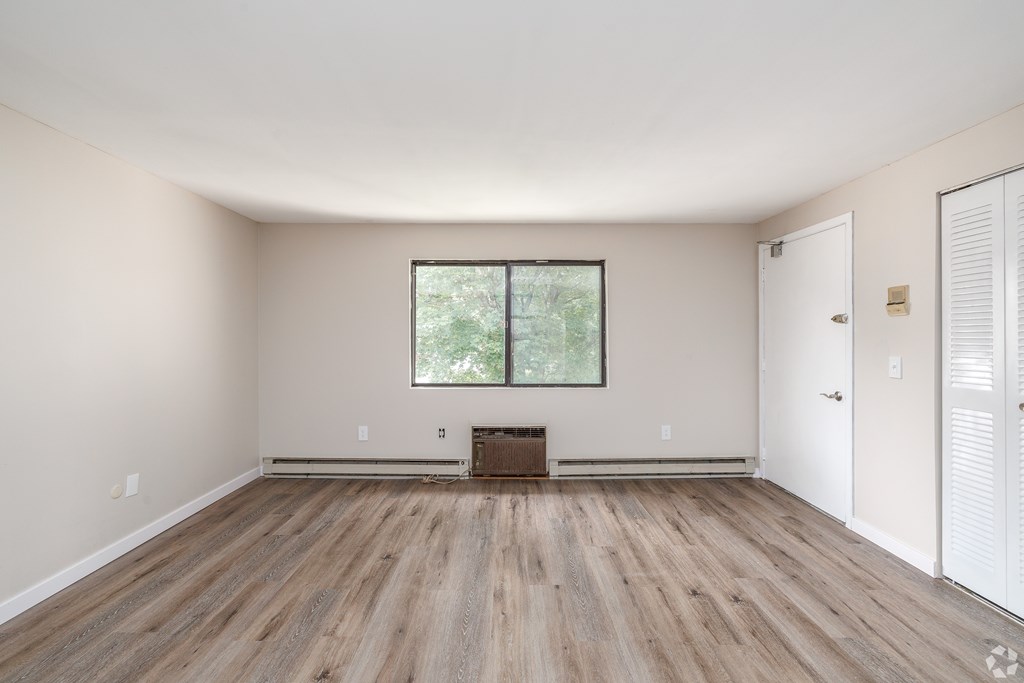 A room with wooden flooring and a window.